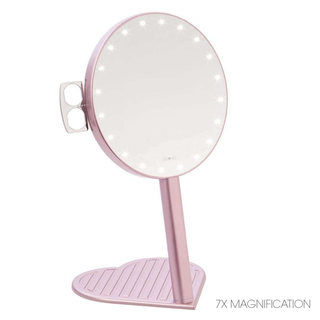 The RIKI GRACEFUL compact vanity mirror in rose gold, featuring a 7X magnifying handheld mirror with LED lights and a heart-shaped base.