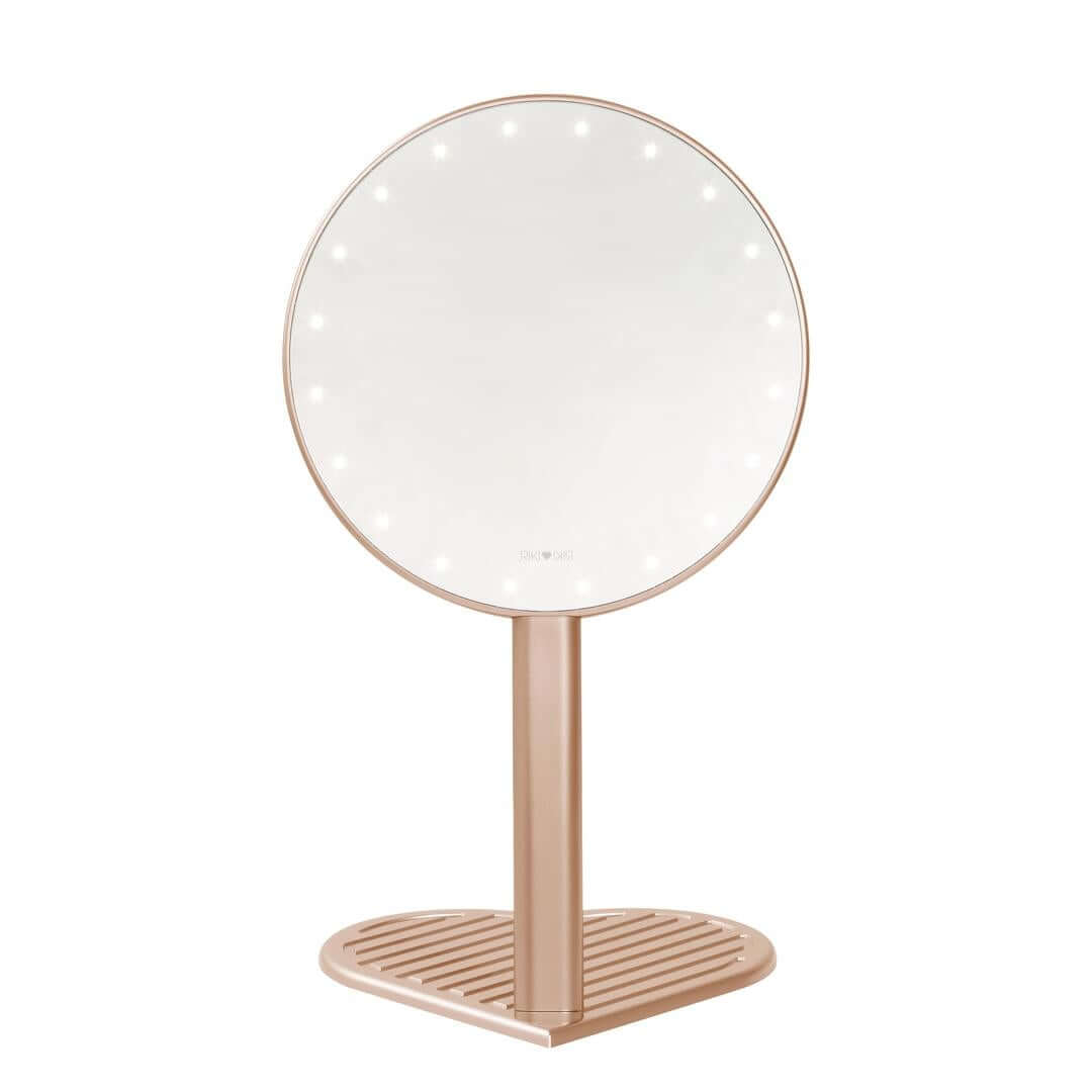 The RIKI GRACEFUL handheld magnifying face mirror in rose gold, featuring 7X magnification, LED lights, and a charming heart-shaped base.