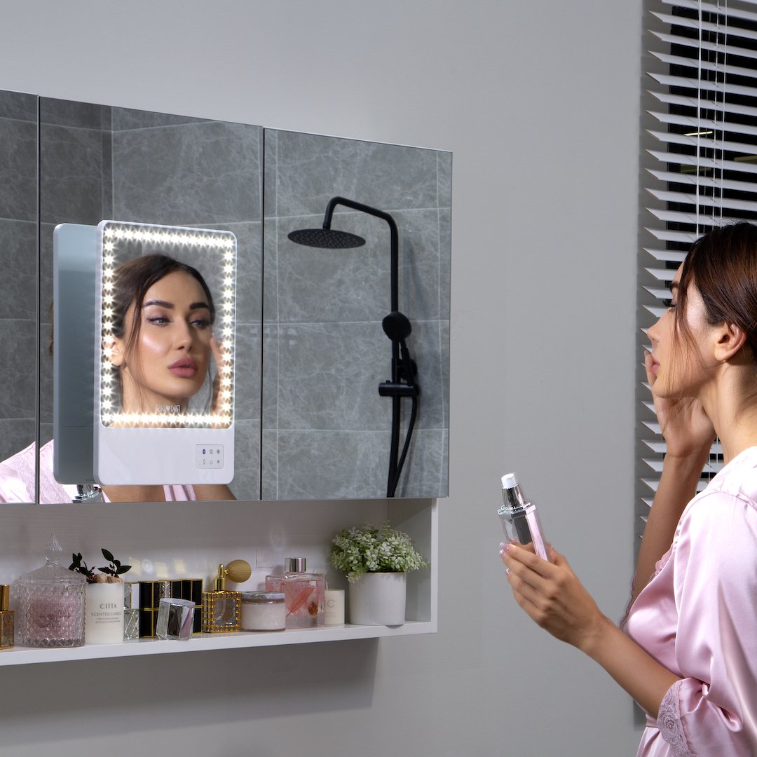 Experience ultimate convenience with the RIKI Babe Travel Kit in White, shown mounted on a bathroom mirror. Perfect for flawless makeup application during your travels!